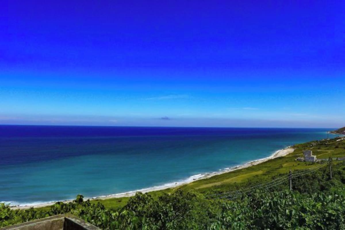 A coastal landscape with a clear view of the ocean and beach.
