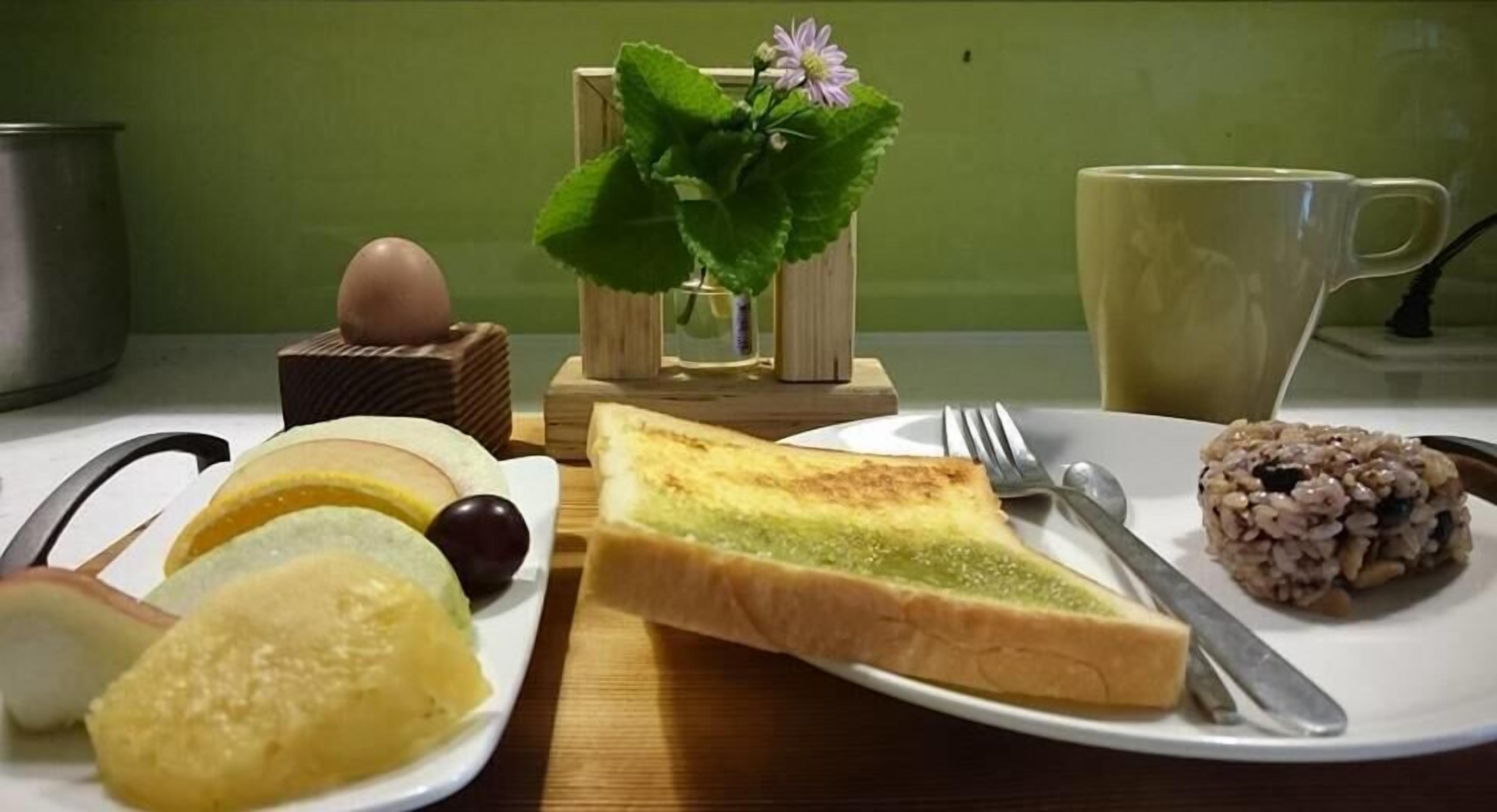 Een ontbijtsetting met toast, een kom granen, een kop koffie en een kleine plant.