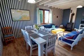 Un espace repas comprenant une table et des chaises, un canapé et un téléviseur.