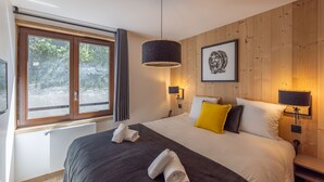 A bedroom with a large bed, two bedside lamps, a framed picture on the wall, and a window with curtains. - Cristal Lodge by Daddy Pool - TerresenS (Saint-Chaffrey)