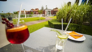 Una mesa con dos bebidas: una copa de vino tinto y un vaso de agua con una rodaja de lima.