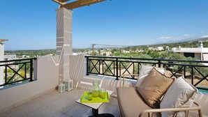 A balcony with a view of a cityscape, a table with a pitcher and glasses, and a sofa with cushions. - Adele Villa with Pool & Terrace (Adele)