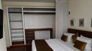 A hotel room with a bed, a wardrobe, and a desk. - Executive D2W suites and residences (machakos)