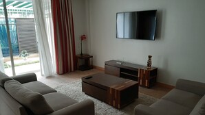 A modern living room with a flat-screen TV, two sofas, a coffee table, and a TV stand. - Executive D2W suites and residences (machakos)