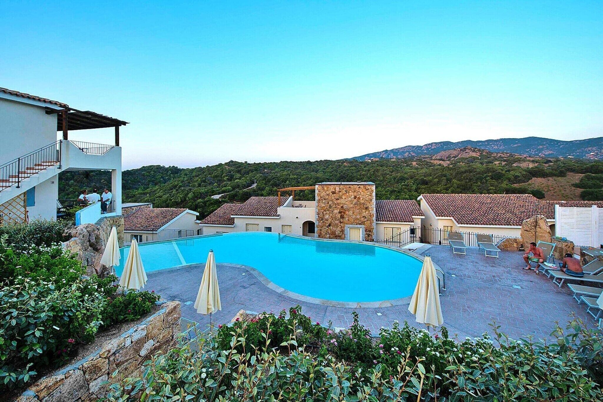 Una piscina circondata da edifici con montagne sullo sfondo.