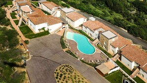 Un quartier résidentiel comprenant plusieurs maisons, une piscine et une allée pavée.