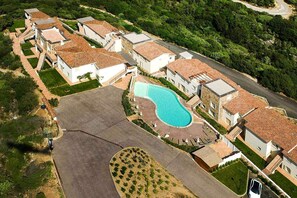 A residential area with multiple houses, a swimming pool, and a paved driveway.