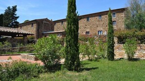 A stone building with a courtyard, surrounded by greenery and trees. - Apartment in Campiglia Marittima (Campiglia Marittima)
