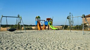 A playground with swings and slides on a sandy beach. - Apartment in Campiglia Marittima (Campiglia Marittima)