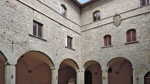 Un bâtiment en pierre doté de nombreuses arcades et d’une cour intérieure.
