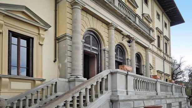 Un bâtiment de style classique, doté d’un grand escalier menant à un balcon.