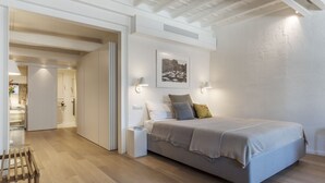 A modern bedroom with a large bed, bedside tables, and a picture on the wall.