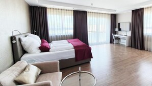 A hotel room with a bed, a desk, a chair, and a round table. - TH39 Trend Hotel (Bad Vilbel)