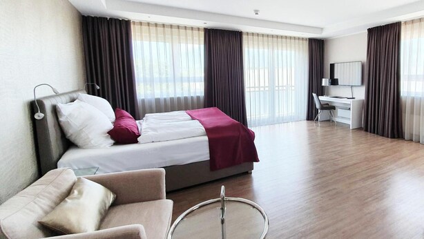 A hotel room with a bed, a desk, a chair, and a round table. - TH39 Trend Hotel (Bad Vilbel)