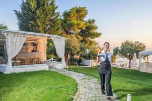 A well-maintained outdoor area with a covered seating area, a pathway, and lush greenery.