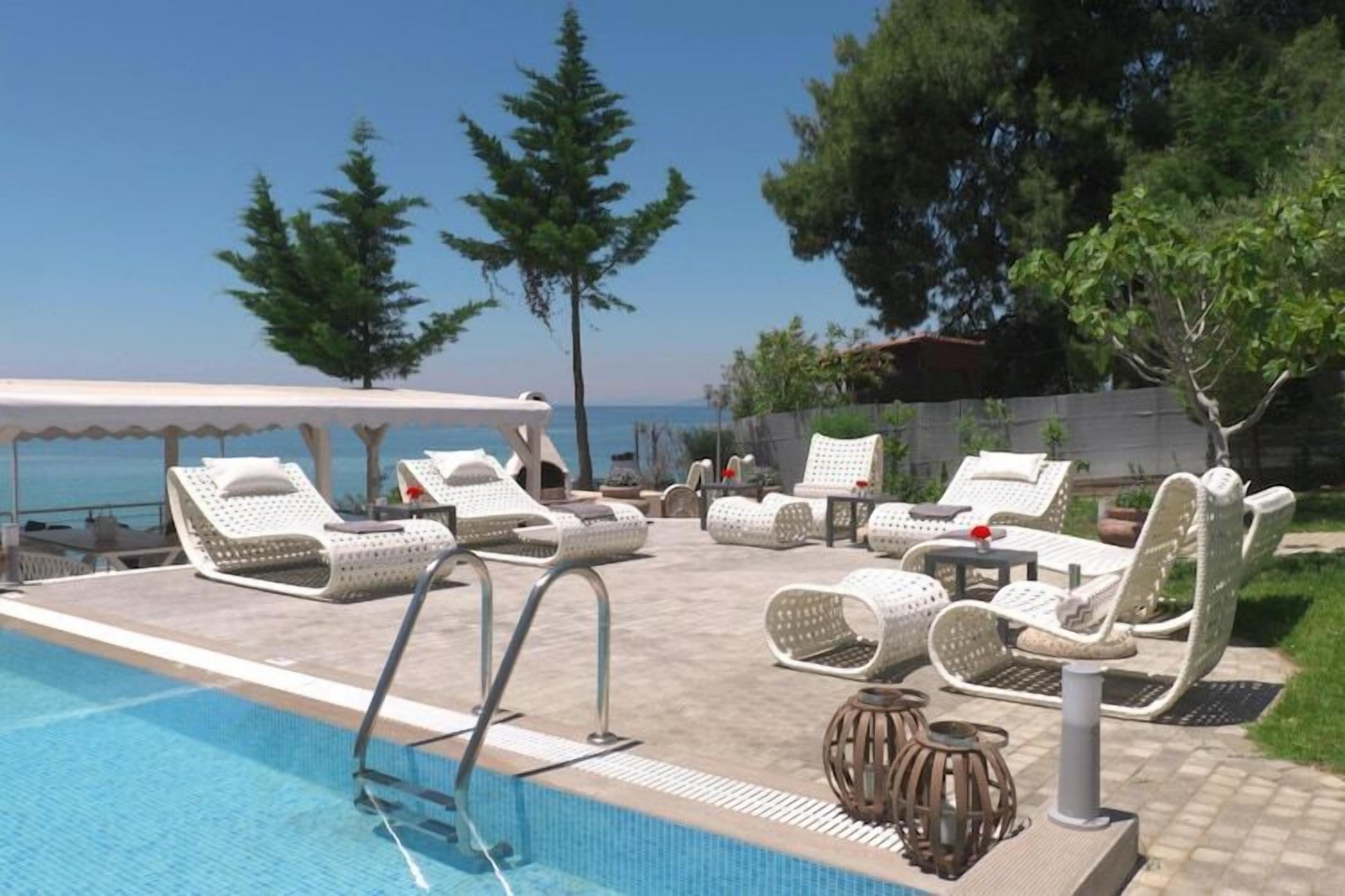 A poolside area with lounge chairs and a pool.
