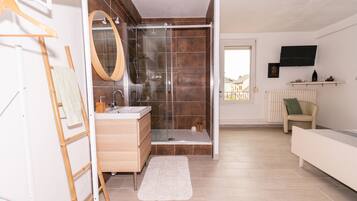 A modern bathroom with a shower, sink, and vanity.