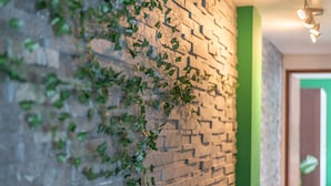 Un mur de briques orné de plantes grimpantes et un mur d’accent de couleur verte.