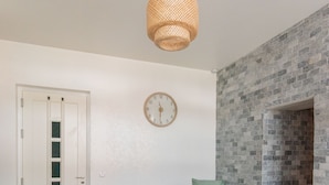 Une chambre à coucher moderne avec un lit, une table à manger avec de la nourriture, une horloge et un mur en briques.
