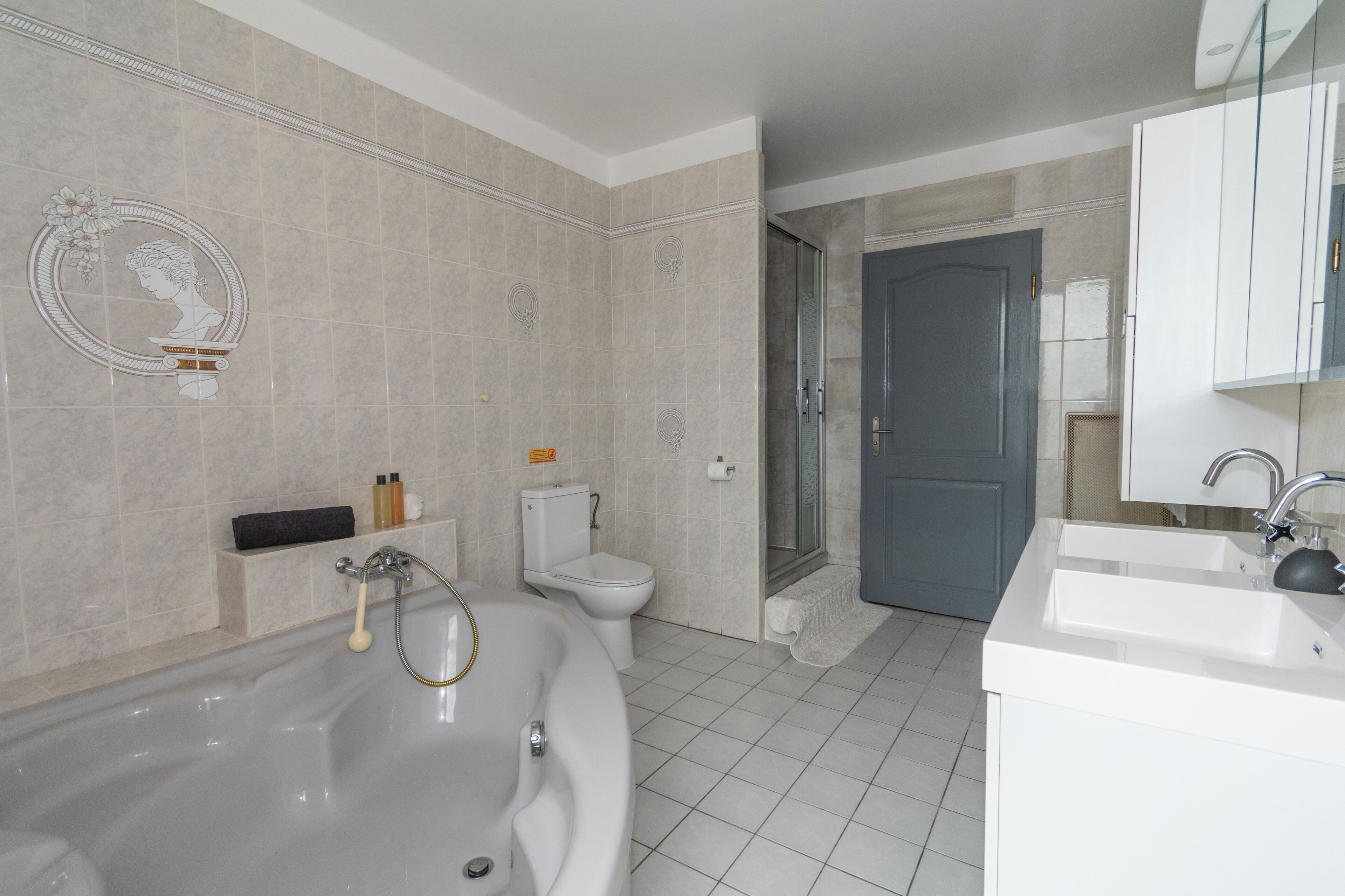 Un baño moderno con una bañera independiente, inodoro y lavamanos.