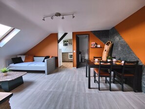 A modern loft apartment with a loft bed, dining area, kitchen, and a large window.