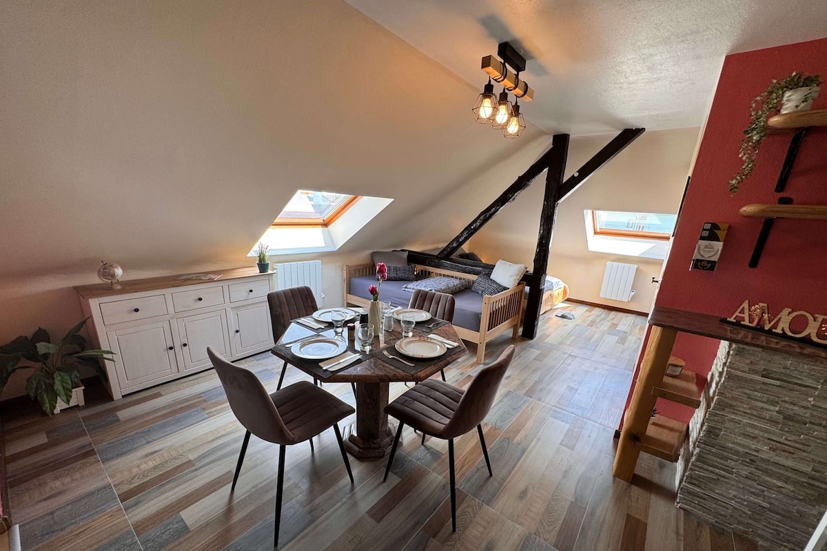 Een knus loft appartement met een eethoek, een hoogslaper en een keuken.