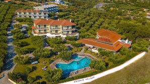 An aerial view of Asteris Village with multiple buildings, a large swimming pool, and surrounding greenery. - Asteris Village Gerakini Holiday Resort (Gerakini)