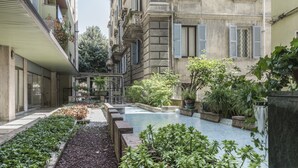 A courtyard with a swimming pool, surrounded by greenery and traditional architecture. - Olympus Verona Relais (Verona)