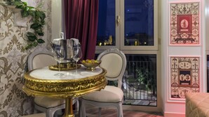 A dining area with a table set for two, a vase, and a bowl of fruit. - Olympus Verona Relais (Verona)