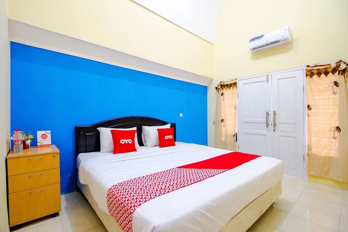 Une chambre d’hôtel avec un lit, une armoire et une table de chevet.