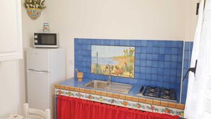 Eine kleine Küche mit Mikrowelle, Spüle und Herd.