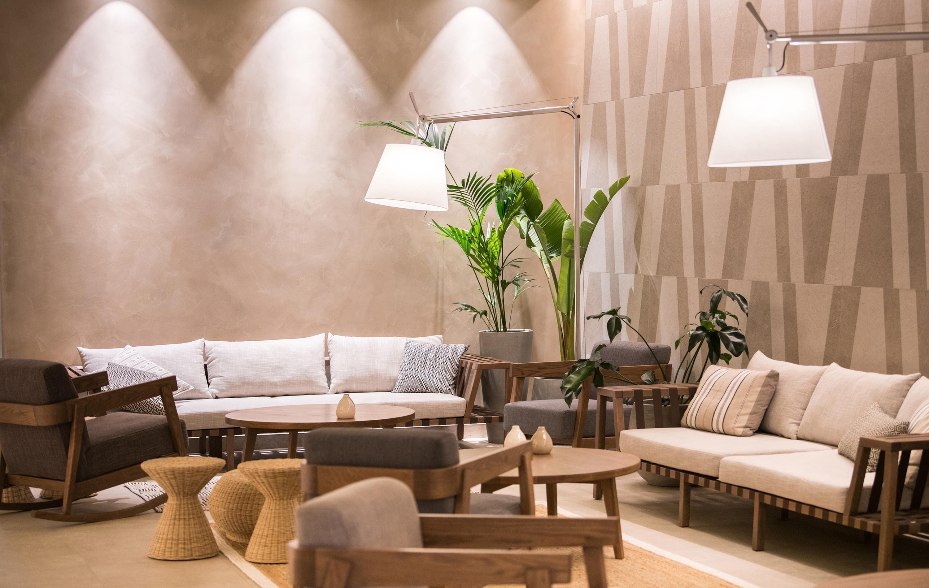 A modern living room with a sofa, chairs, a coffee table, and a lamp.