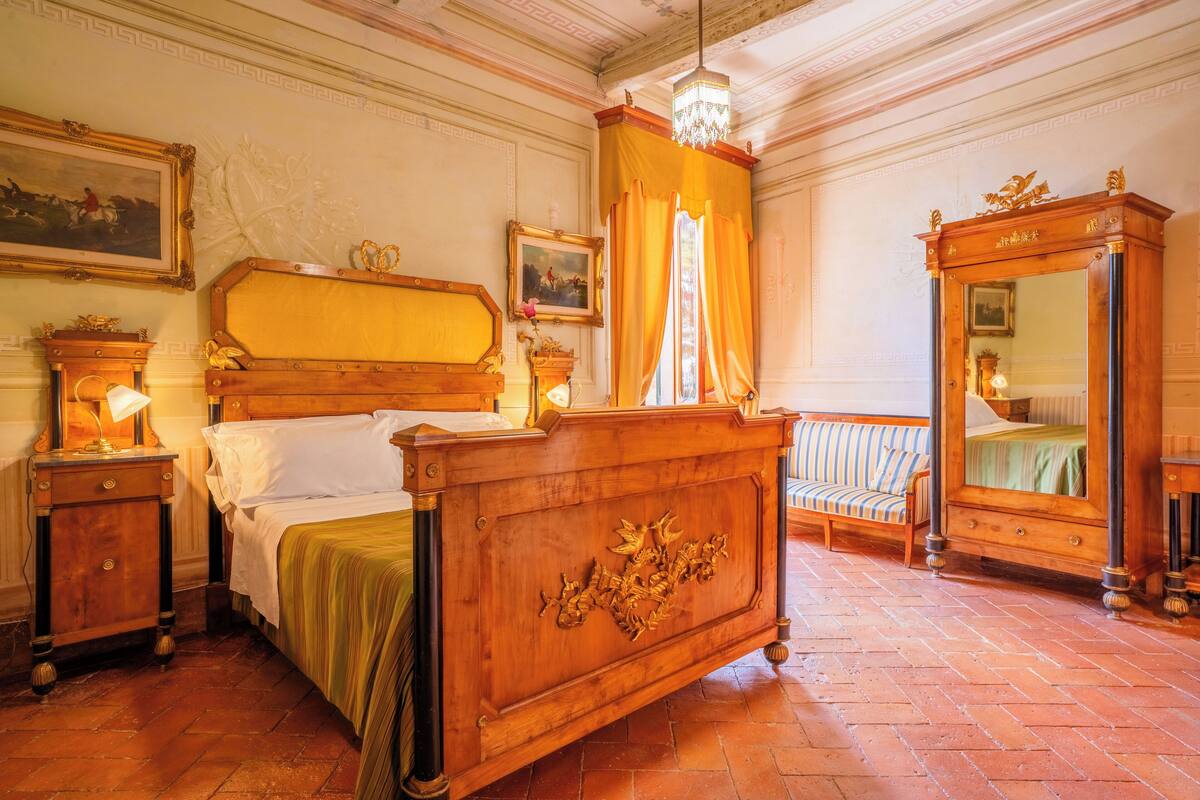 Une chambre à coucher de style traditionnel, avec un lit en bois, une table de chevet, une commode et un miroir.