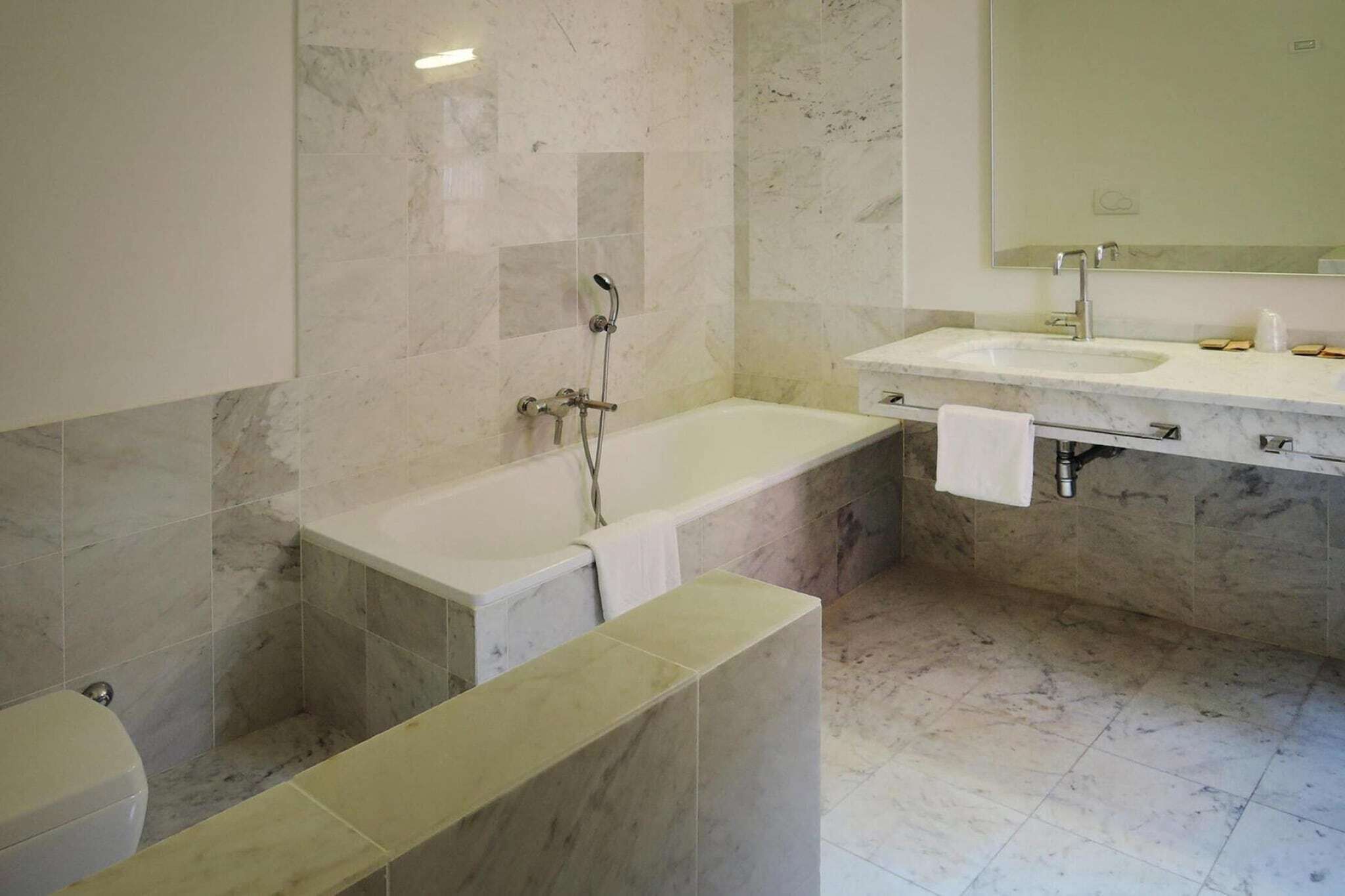 Une salle de bain moderne avec une baignoire, un lavabo et un miroir.