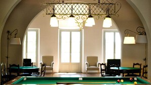 A pool table with balls, a chandelier, and chairs in a room with large windows. - Apartment in Tuscany with Large Pool (Rignano sull'Arno)