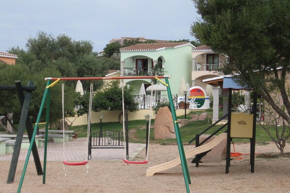 A playground with swings, a slide, and a climbing structure.