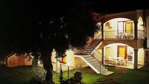 A two-story building with a staircase leading to the upper floor. There is a balcony with outdoor seating on the upper level. - Apartment in in Badesi with Shared Pool (Badesi)