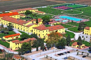 A large yellow building complex with multiple structures, a swimming pool, and a well-maintained lawn area. - Terrace Vibes in the Italian Sun (Piombino)