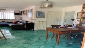 A living room with a sofa, a dining table with chairs, a lamp, and a bookshelf. - Penthouse in the center - Pompeii (Pompei)