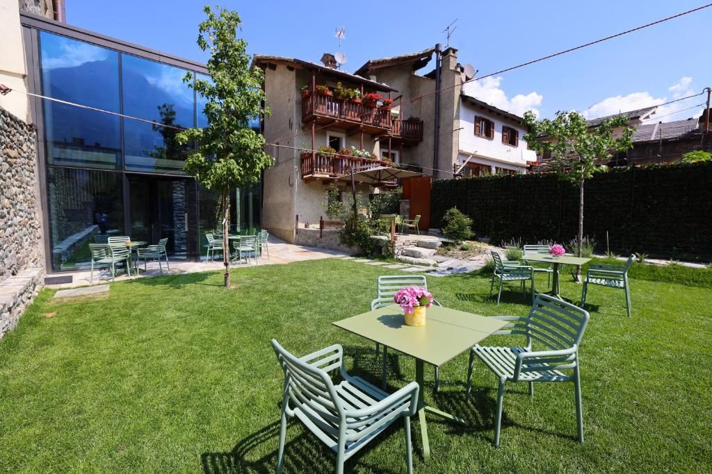 Un cortile con prato verde, arredi da esterno e un edificio con balconi.