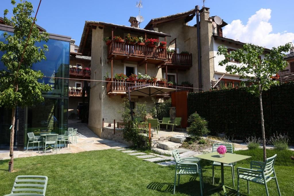 Un edificio residenziale con un balcone, un'area salotto all'aperto e un giardino.