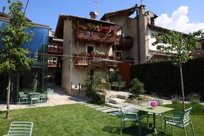 A residential building with a balcony, outdoor seating area, and a garden. - Relais Bondaz (Aosta)