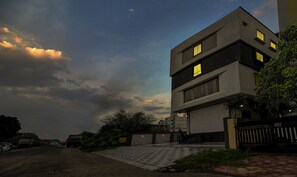 Vista frontal de la propiedad por la tarde o noche
