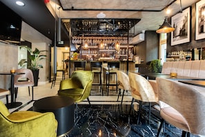 A bar area with seating and a bar counter. - Hotel M29 (Kraków)