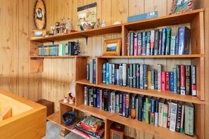 A wooden bookshelf filled with books, a framed picture, and small decorative items. - Skyview Cabin - Spectacular View, 2 BR, 2 1/2 BA, Brand New Hot Tub, Firepit (Maggie Valley)