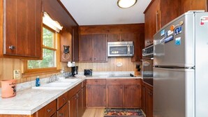 A kitchen with wooden cabinets, a stainless steel refrigerator, a microwave, and a sink. - Skyview Cabin - Spectacular View, 2 BR, 2 1/2 BA, Brand New Hot Tub, Firepit (Maggie Valley)