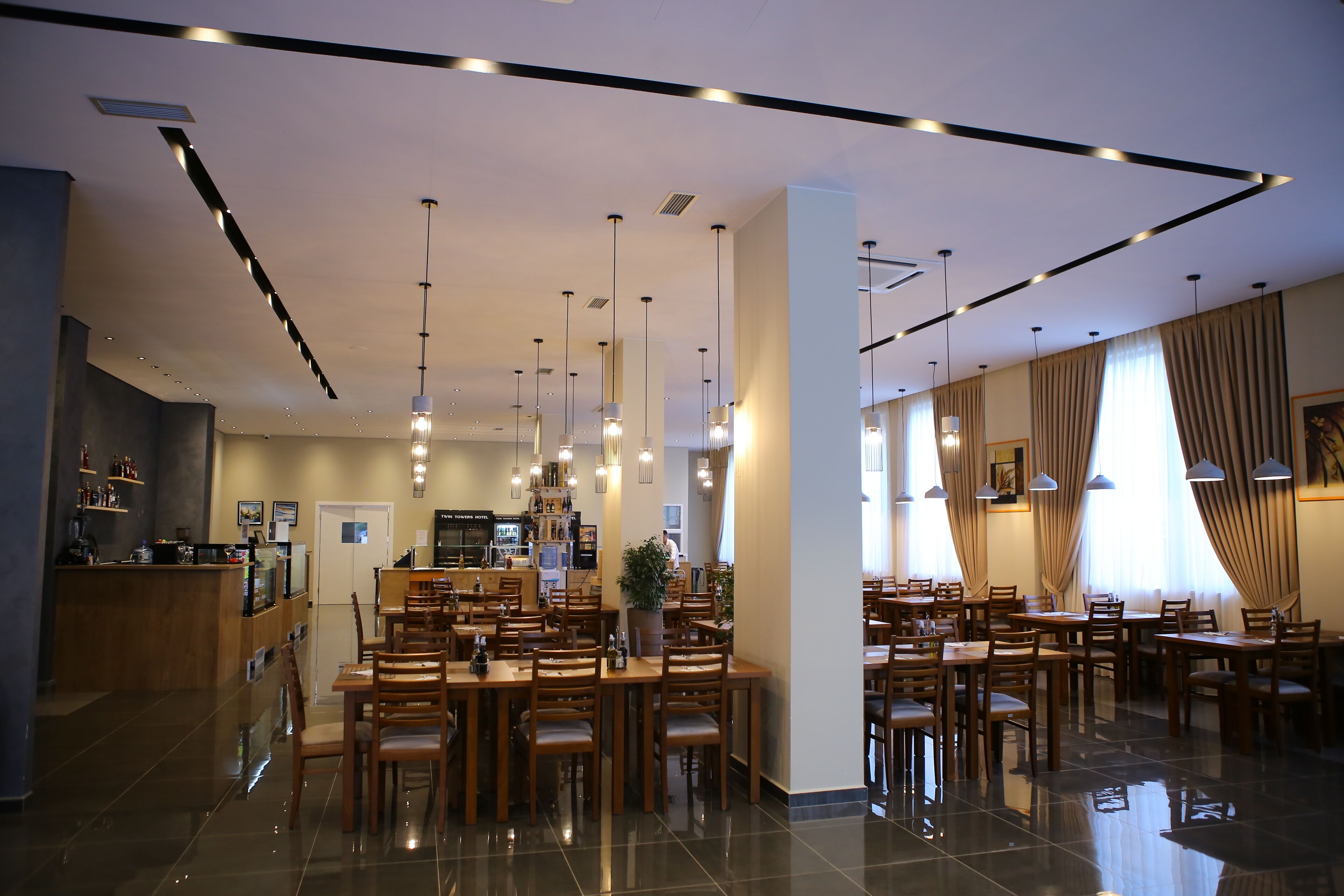 Eine großzügige Hotelhalle mit verschiedenen Restaurants, einer Rezeption und einer Bar.