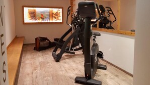 A gym with exercise equipment, a wooden floor, and a large mirror. - Apartment in Wildschönau by Schatzberg Lift (Wildschönau)