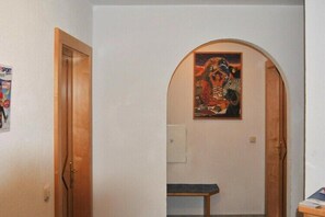 Stylish hallway with a wooden door and arched entrance.