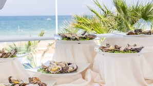 A table set with oysters on the beach overlooking the ocean. - Hotel Sporting (Casalbordino)